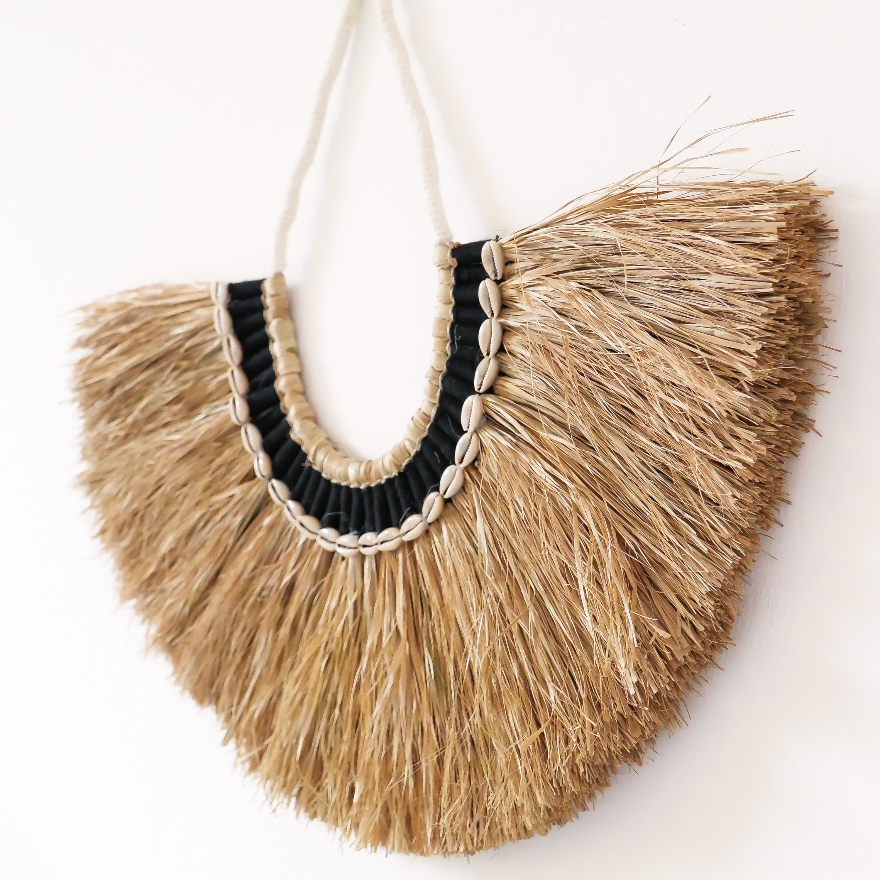 Raffia wall decor with cowrie shells